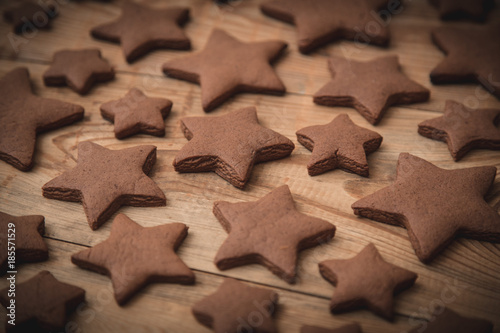 Christmas gingerbread cakes in shape of stars on rustic wooden table.