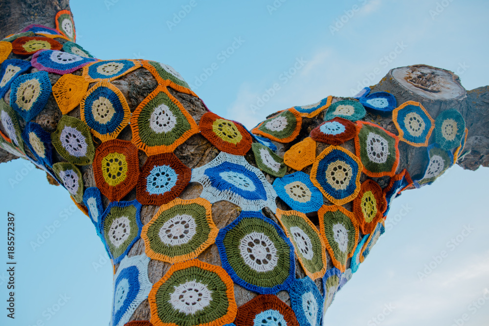 Fototapeta premium Tree with storm yarn. Sewn with coloured wool, street and creative art