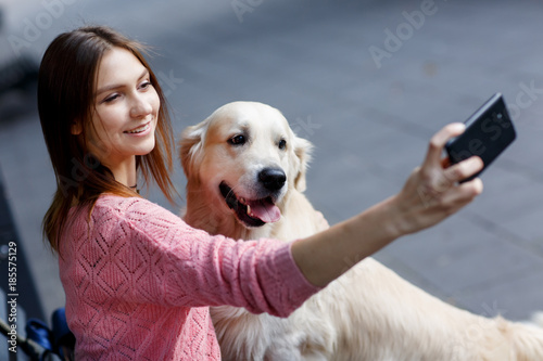 Photo of woman on bench doing selfie with dog photo