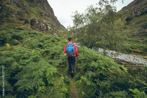 Male hiker walking on lushy countryside landscape photo