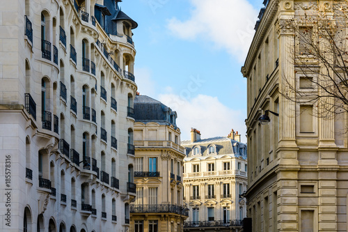 Typical residential buildings of Haussmannian and Art Deco style in chic neighborhoods of Paris, France, at sunset. © olrat