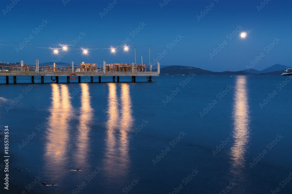 Sunset view of restaurant's pier in Ortakent, Mugla province, Turkey.