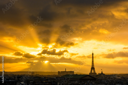 Cityscape of a blazing sunset over Paris skyline with the silhouette of the Eiffel tower standing out against the red stormy sky.