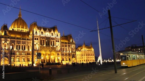 tram goes in front of parliament building in Budapest, Hungary at night