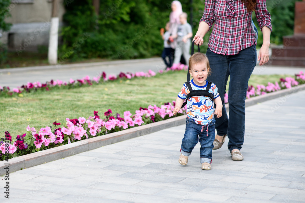 Mom insures her child during a walk Mom insures her child during a walk