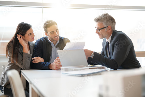 Young couple meeting financial advisor for home investment