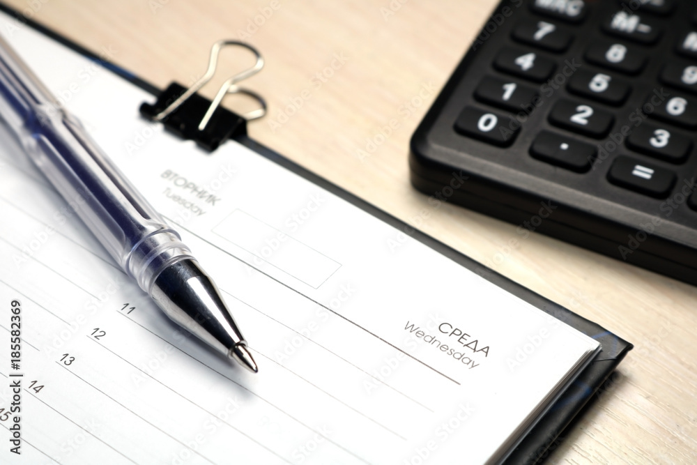 Notepad for notes on a wooden background. Daily log. Notepad for notes on a wooden background. Daily log.