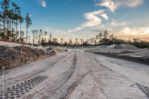 construction site with construction materials, vehicles and earth movers