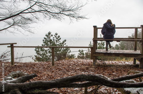 Woman follows her thoughts on a bench in nature.