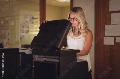 Executive using photocopy machine in office photo