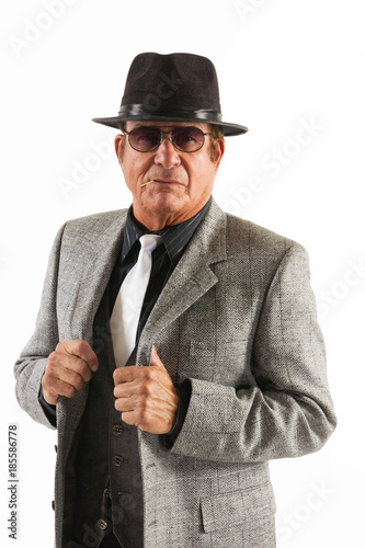 Mafia Guy in Fine Grey Suit and Black hat on White Background.  An older gentleman in a fine grey  suit and black hat in front of a plain, white background..