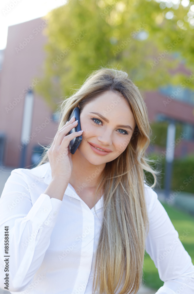 Confident blonde businesswoman in shirt calling outdoor Confident blonde businesswoman in shirt calling outdoor