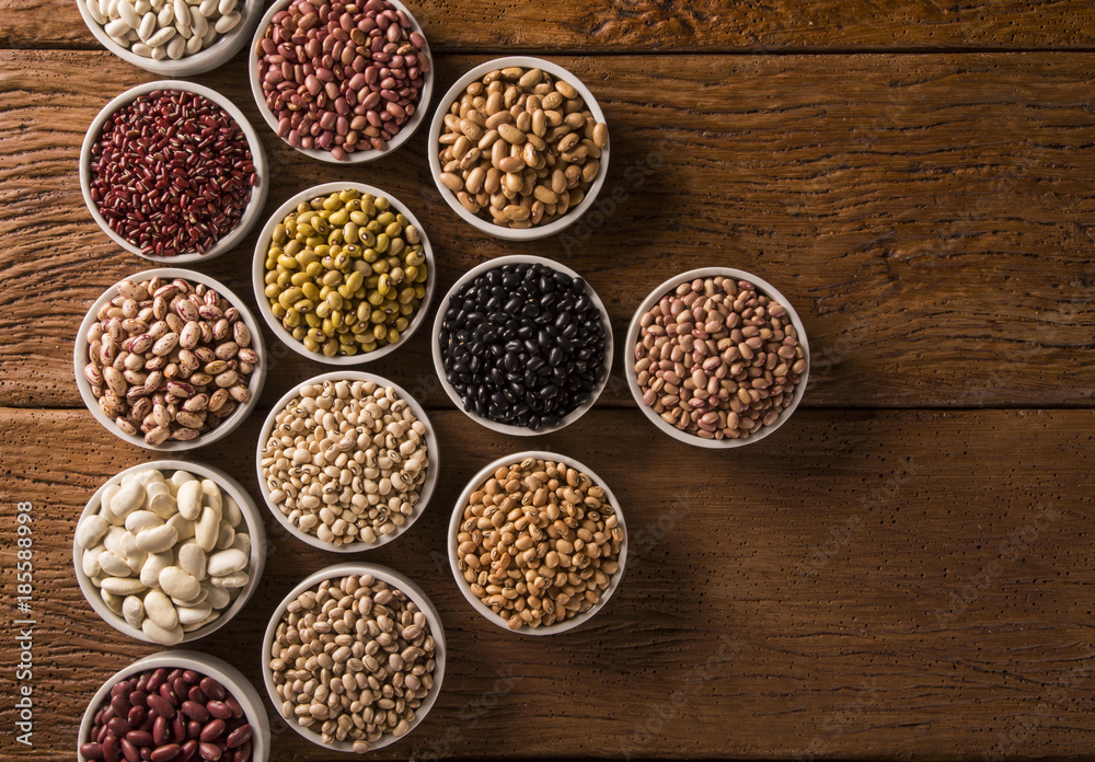 Assorted beans in bowls on wood background Assorted beans in bowls on wood background