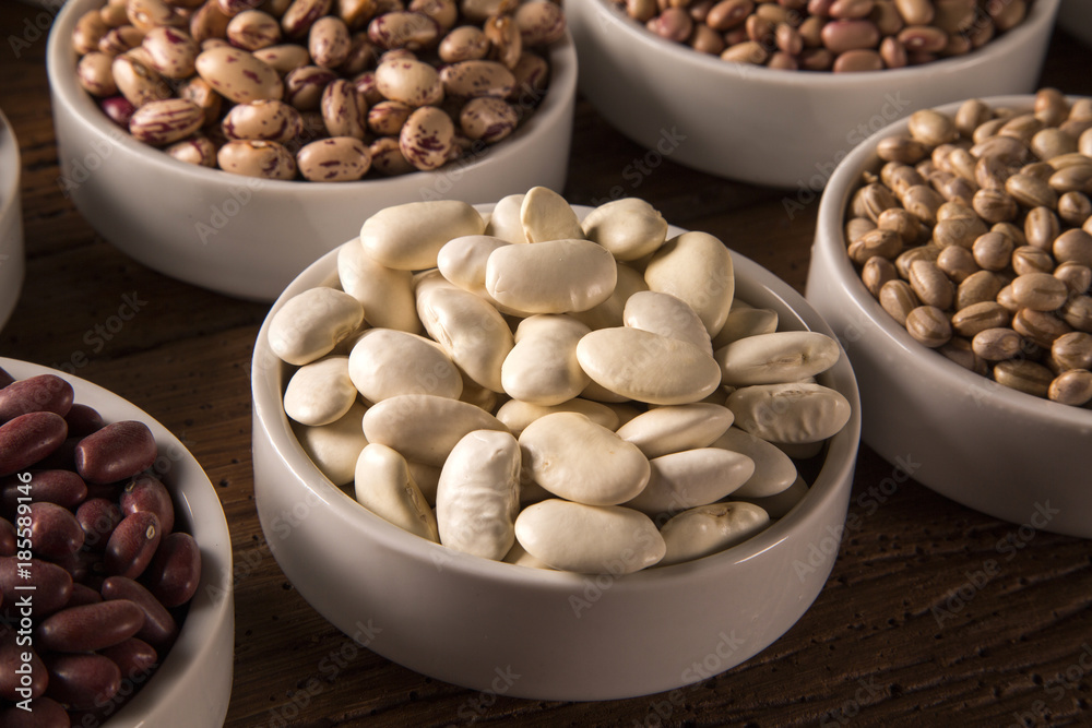 Assorted beans in bowls on wood background Assorted beans in bowls on wood background