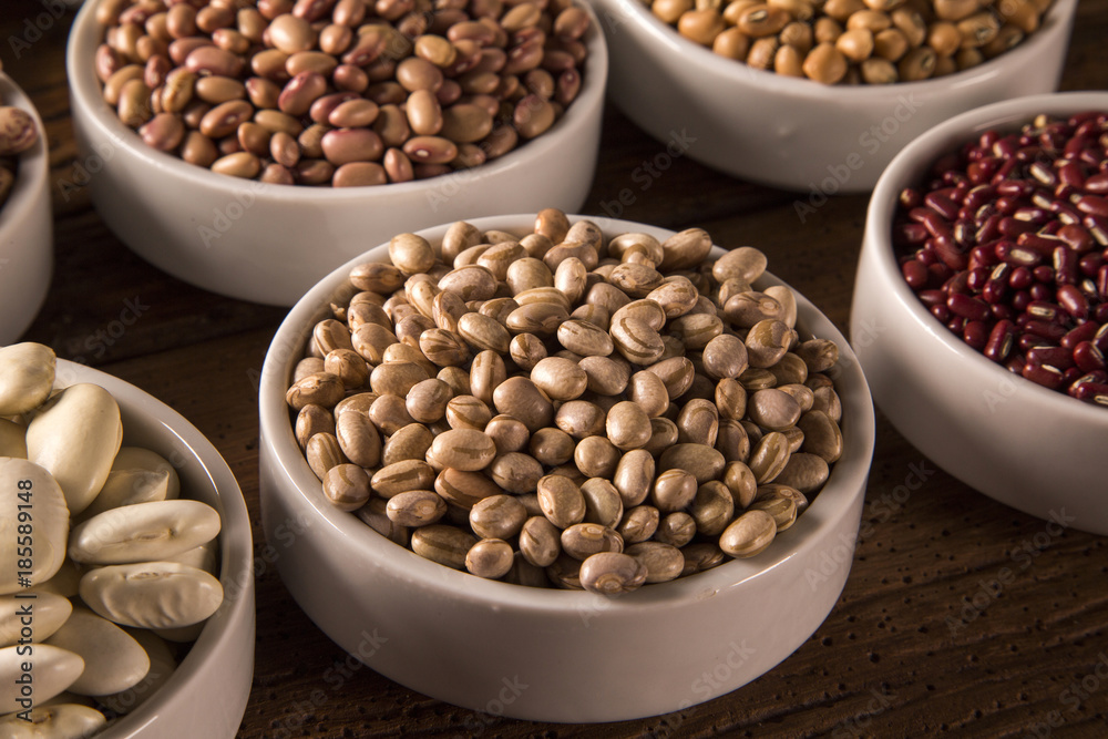 Assorted beans in bowls on wood background Assorted beans in bowls on wood background
