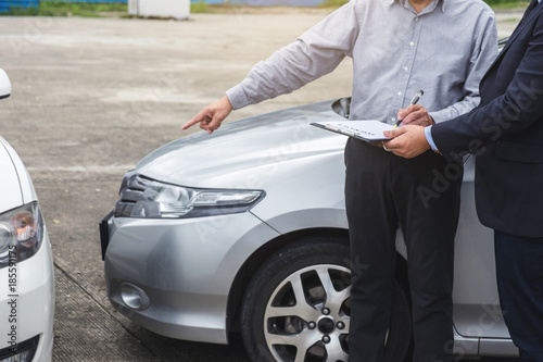 Insurance Agent examine Damaged Car and filing Report Claim Form after accident, Traffic Accident and insurance concept