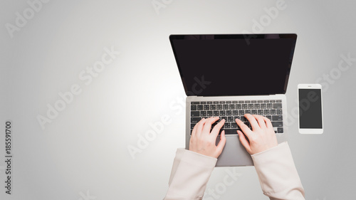 flat lay minimal concept with business woman hand in vintage pink suit and typing on her laptop and put smart phone on isolated white table background
