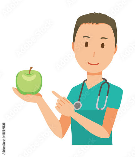 A male doctor wearing a green scrub has an apple