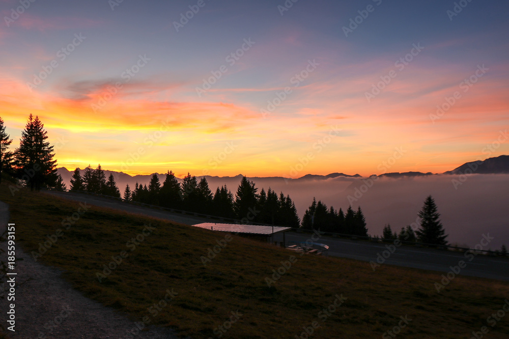 Atemberaubender Sonnenuntergang in den europäischen Alpen über den Wolken