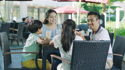 Photography Asian family smiling, eating & drinking outdoor at streetside table