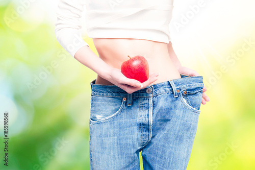 Woman showing an apples in close up of belly stomach