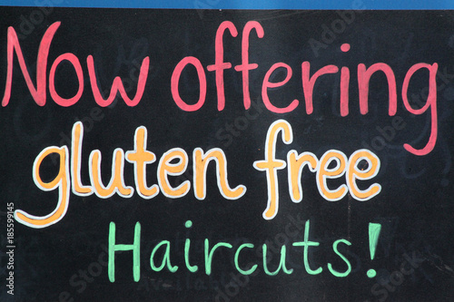 Werbeschild mit der Aufschrift: 'Now offering gluten free hair cuts' 'Bieten gluten-freien Haarschnitt'.Where: San Francisco, USA.When: 11.07.2015. photo