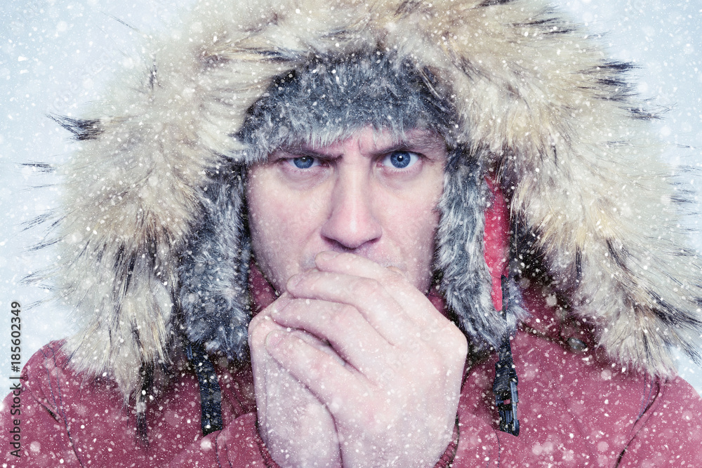 Frozen man in winter clothes warming hands, cold, snow, blizzard Frozen man in winter clothes warming hands, cold, snow, blizzard