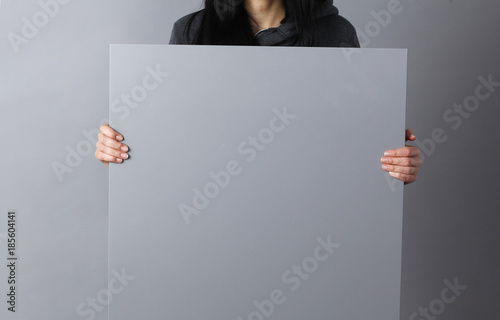 Happy young woman showing and displaying placard ready for your text or product photo