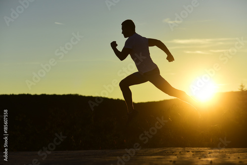 Sportsman jogging in evening catching the sun