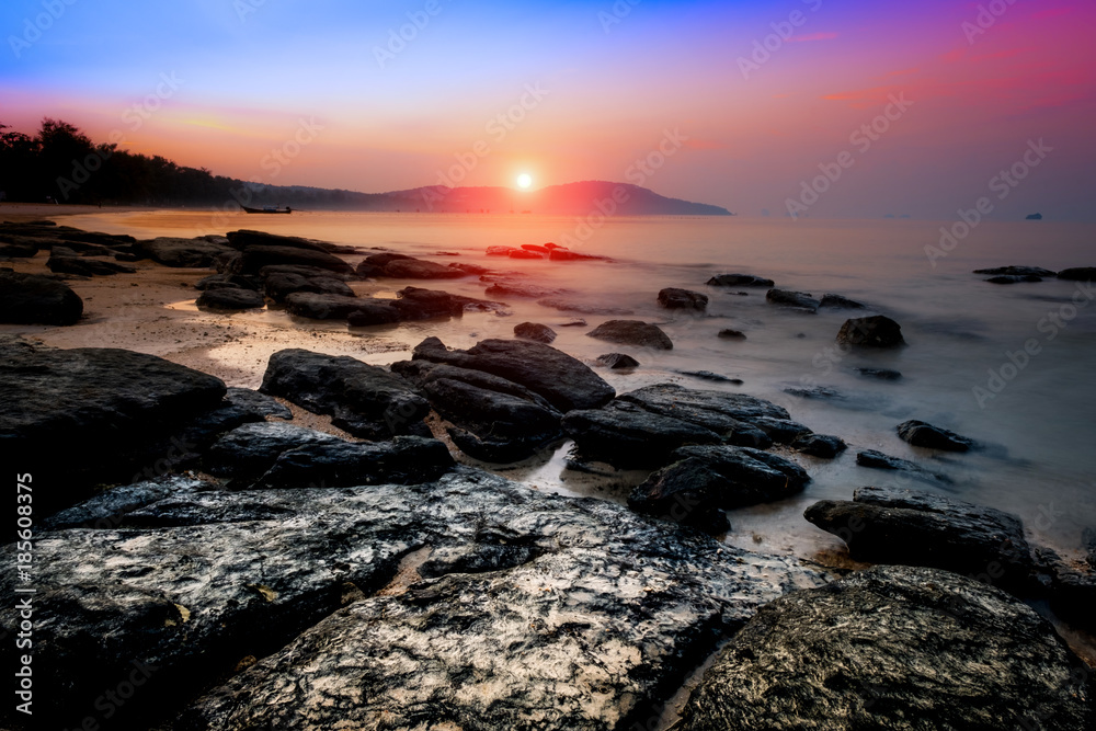 Golden sunset with stones on tropical beach of Krabi, Andaman sea, Thailand. Travel, holidays, recreation concept