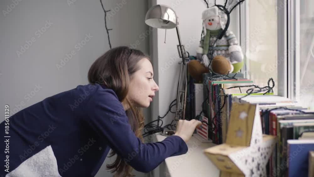 Girl by the window and looking for something in the book Girl by the window and looking for something in the book