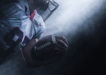 American football player holding ball while running on field