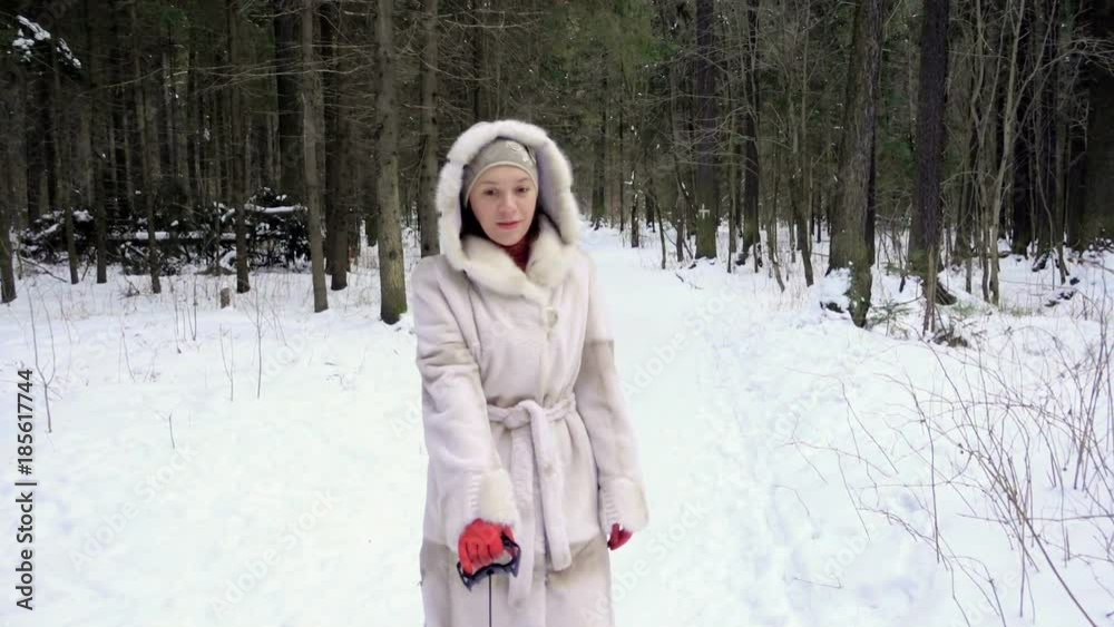 Mom pulls a sled with a child. They walk in the winter forest. Daughter in a warm winter overall. Mom pulls a sled with a child. They walk in the winter forest. Daughter in a warm winter overall.