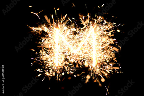 Letter  M  made of sparklers isolated background.