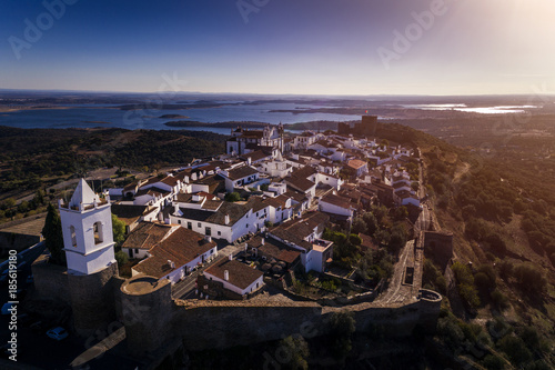 Aerial view of the historic village of Monsaraz in Alentejo with the Alqueva dam reservoir on the background; Concept for travel in Portugal and Alentejo