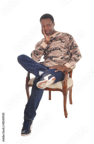 Tall African American man sitting in armchair