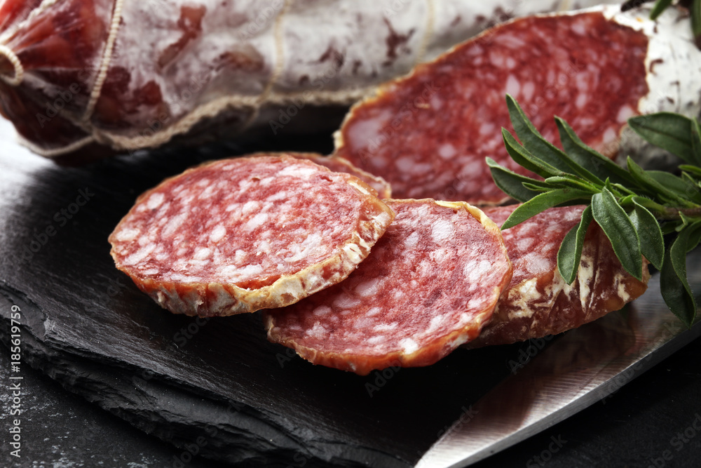 Marble cutting board with sliced salami on it Marble cutting board with sliced salami on it