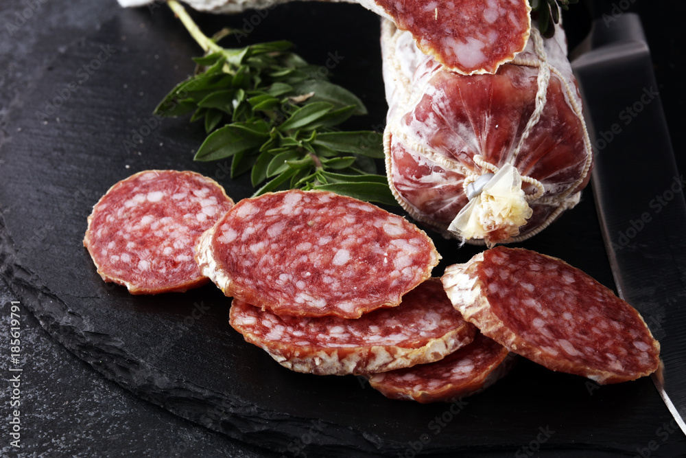 Marble cutting board with sliced salami on it Marble cutting board with sliced salami on it