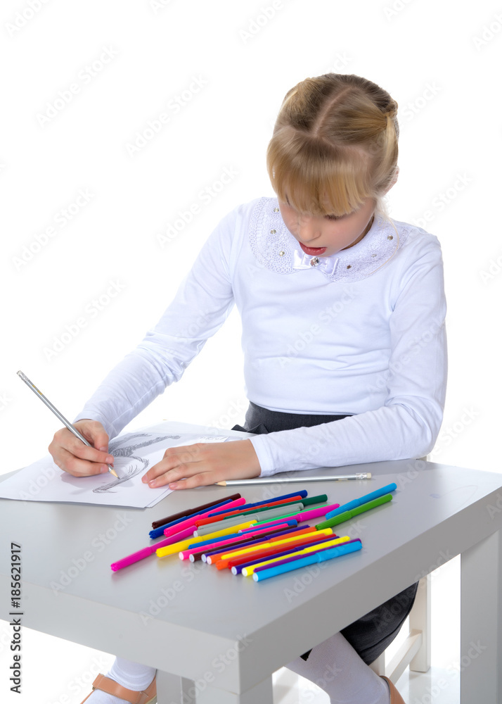 A little girl is drawing at the table. A little girl is drawing at the table.