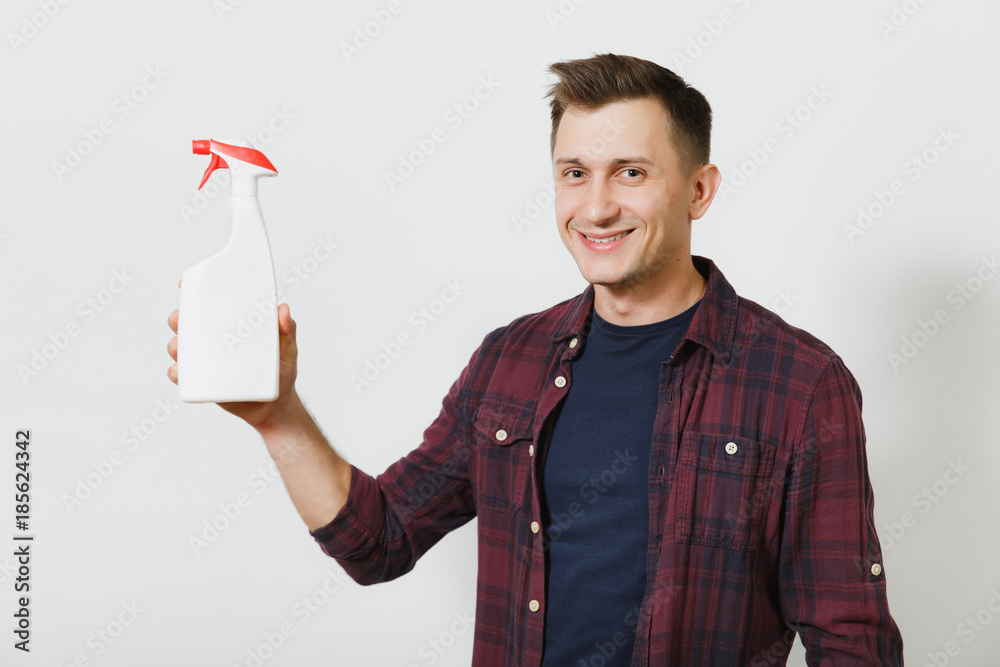 Studio portrait of handsome caucasian smiling young man in shirt with white bottle sprayer cleaner isolated on white background. Copy space for advertisement. With place for text. Housekeeping concept Studio portrait of handsome caucasian smiling young man in shirt with white bottle sprayer cleaner isolated on white background. Copy space for advertisement. With place for text. Housekeeping concept