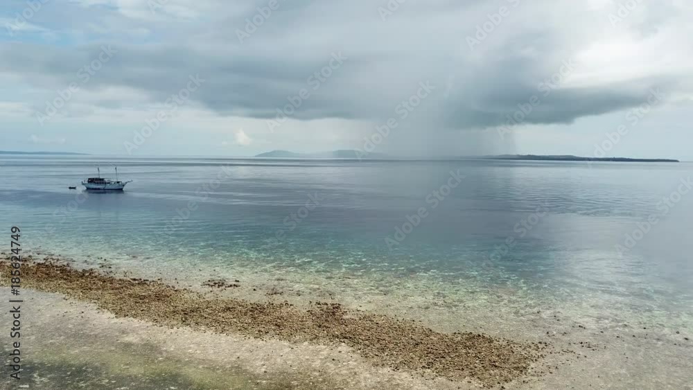 Aerial of Calm Reef and Distant Rain Cloud in Banda Sea Aerial of Calm Reef and Distant Rain Cloud in Banda Sea