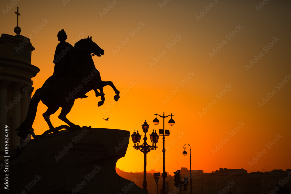 Bronze Horseman at sunset, close up / Statue of Peter Great, silhouette against the sunset, orange sky / 