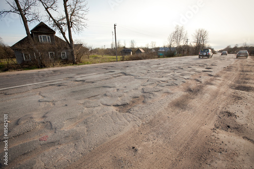 Bad Russian roads / Hole in the asphalt, risk of movement by car, bad asphalt, dangerous road, potholes in asphalt, pit unsafe hole road / russian village road 