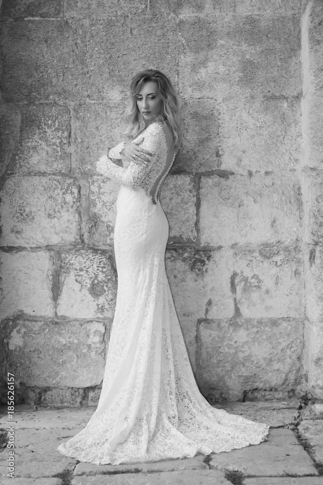Beautiful bride in a white long dress in a city street