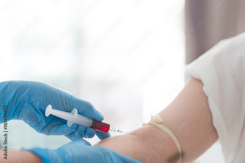 Close up Hand of nurse, doctor or technician in blue gloves taking blood sample from a patient in the hospital. Close up Hand of nurse, doctor or technician in blue gloves taking blood sample from a patient in the hospital.