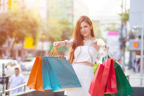 Beautiful Shopping woman with colorful shopping bags walking in the city.