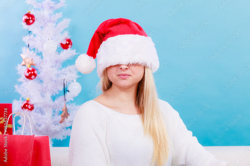Woman wearing Santa hat that covers her eyes Woman wearing Santa hat that covers her eyes