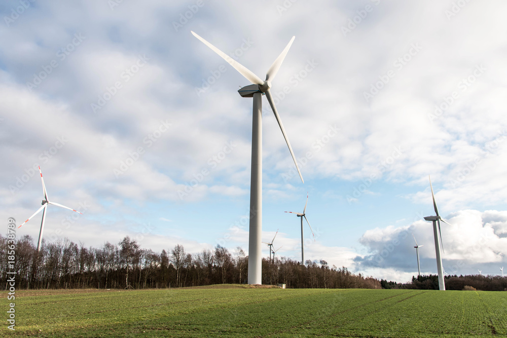 A panorama view over wind farm landscape in Germany with white generator turbines A panorama view over wind farm landscape in Germany with white generator turbines