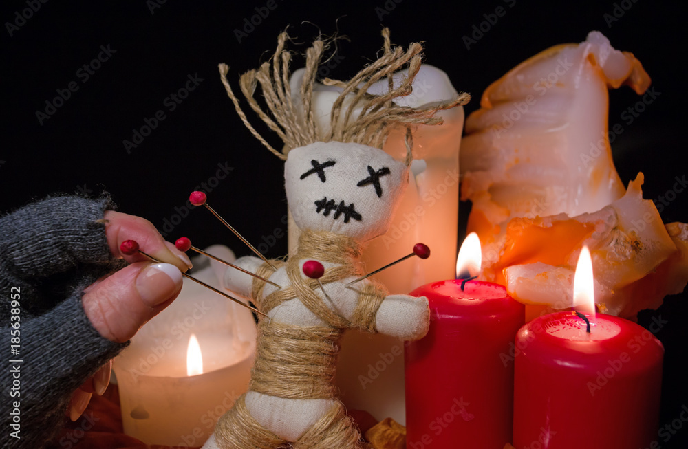 Bei einer Voodoo Ritual leuchten Kerzen und in eine Puppe werden Nadeln  gestochen Stock-Foto | Adobe Stock