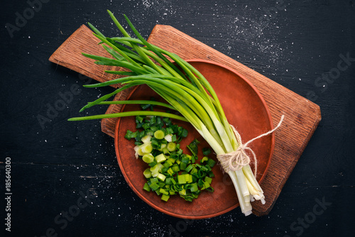 Fresh green onion on a wooden background. Top view. Free space for your text. photo